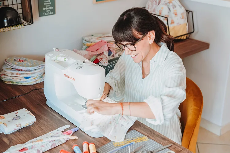 Anna cuce a macchina un accessorio per bebè.