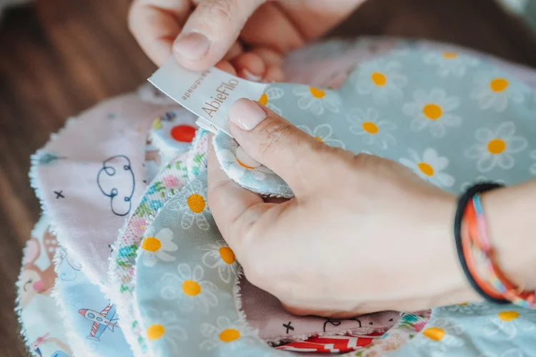 Anna applica etichette e rifiniture a un prodotto handmade.