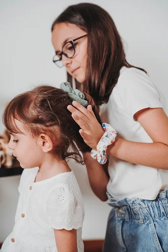 Bambina con coda alta e scrunchie fatto a mano.